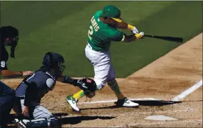  ?? JED JACOBSOHN — THE ASSOCIATED PRESS ?? The Athletics’ Khris Davis hits an RBI-sacrifice fly against the Seattle Mariners on Saturday.