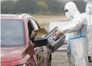  ?? Petr David Josek / Associated Press ?? A man votes by car in Prague. The Czech Republic has the highest per capita infection rate in Europe.