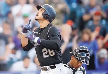  ?? DAVID ZALUBOWSKI/ASSOCIATED PRESS ?? Colorado’s Nolan Arenado (28) gestures as he crosses home plate after hitting the first of two home runs Friday night at Coors Field. The Rockies rallied from a 5-1 deficit to defeat the Baltimore Orioles.