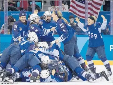  ?? Carlos Gonzalez Minneapoli­s Star Tribune ?? MEGHAN DUGGAN, second from right, who added gold to the silver medals she won after losses to Canada in the 2010 and 2014 Olympics, joins the celebratio­n after the U.S. edged its northern neighbor in a shootout.