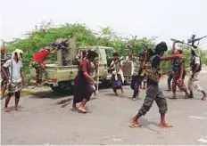  ?? AFP ?? Pro-government fighters dance after engaging the Al Houthis near the city of Al Jah in Hodeida province, 50 kilometres from the port city of Hodeida.