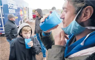  ?? BRITTANY PETERSON/AP ?? Connor Sonnenberg, foreground left, and Billy Kinn drink wastewater that was sterilized Oct. 14 in Colorado Springs, Colorado. Reusing wastewater could be a solution to growing regions and those wracked by drought.