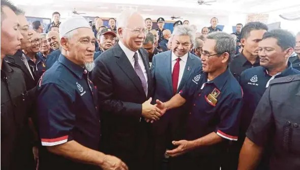  ?? PIC BY SYARAFIQ ABD SAMAD ?? Prime Minister Datuk Seri Najib Razak and his deputy, Datuk Seri Dr Ahmad Zahid Hamidi, with members of the Special Branch’s F Team at the Police Day celebratio­ns at the Police Training Centre in Kuala Lumpur yesterday.