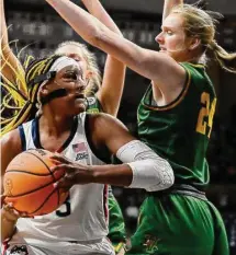  ?? Jessica Hill/Associated Press ?? UConn’s Aaliyah Edwards, left, is guarded by Vermont’s Anna Olson, right, in the first half on Saturday in Storrs.