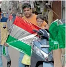  ?? AP ?? A pigeon injured by a kite string is treated at Charity Birds Hospital in New Delhi, and (right) people carrying kites to fly on Independen­ce Day in the old quarters of New Delhi. —