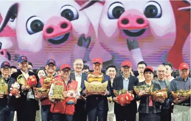  ??  ?? One day after he spoke with President Donald Trump, Foxconn CEO Terry Gou (center) poses during a year-end company carnival ahead of the Chinese New Year of the Pig in Taipei.