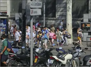  ?? ORIOL DURAN, THE ASSOCIATED PRESS ?? Tourists and residents flee the scene in Barcelona Thursday, after a white van jumped the sidewalk in the historic Las Ramblas district, crashing into a summer crowd of residents and tourists and injuring more than 100, police said.