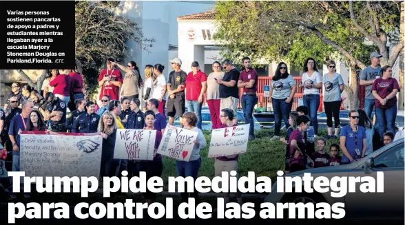  ?? /EFE ?? Varias personas sostienen pancartas de apoyo a padres y estudiante­s mientras llegaban ayer a la escuela Marjory Stoneman Douglas en Parkland,Florida.