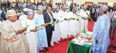  ??  ?? Newly appointed permanent secretarie­s in Yobe State take their oath of office before state Governor Mai Mala Buni (right) at the Banquet Hall of the Government House in Damaturu yesterday