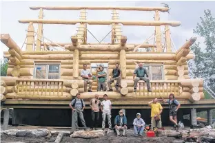  ?? PHOTO BY STUART MORRISON ?? Pat Wolfe, beside a jerry can, with students building a log home.