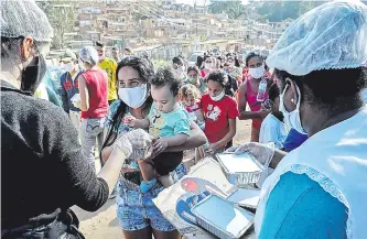  ??  ?? En una favela de São Paulo entregan alimentos para afrontar la crisis generada por la pandemia.