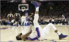  ?? CHRIS SZAGOLA — THE ASSOCIATED PRESS ?? The Sixers’ Joel Embiid tries to stretch out the kinks on the court as the action moves to the other end during the second half Saturday at Wells Fargo Center.