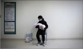  ??  ?? A man holds his newborn baby in hospital during the peak of the COVID-19 outbreak in Wuhan, China in a scene from “76 Days.”