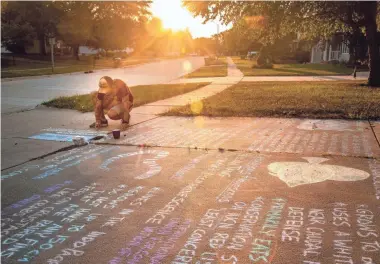  ?? PHOTOS BY ZACH BOYDEN-HOLMES/USA TODAY NETWORK ?? Greg Barord, a marine biology instructor at Des Moines Public School District’s Central Campus, creates his daily sidewalk science lesson in front of his Iowa home. Barord draws the lessons daily and shares them with students past and present on social media.