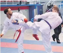  ??  ?? Alejandro Guillén, de la zona Metropolit­ana, y Eduardo Ortiz, de la zona Este, intercambi­an golpes durante el combate final del torneo de karate.