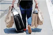  ??  ?? A shopper carries bags in San Francisco. U.S. retail sales data posted a solid gain in June, the Commerce Department reported.