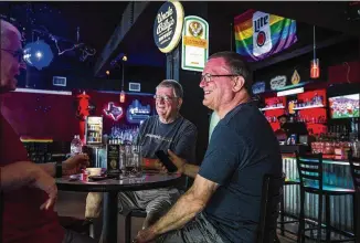  ?? AMANDA VOISARD / AMERICAN-STATESMAN ?? Victor Bockelman, 65, left, Ben Jones-Walters, 72, and his husband, Bill Jones-Walters , 62, patronize the Iron Bear on Thursday in downtown Austin. Police responded to an incident about 1 a.m. in which a firework tossed from a passing car exploded on the patio of the gay bar.