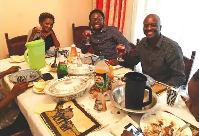  ??  ?? Mkhululi Bhebhe (centre) enjoys a rare home cooked meal with Apostle Vicky Samushonga (left) and Tim Katiyo on his visit to Zimbabwe last week