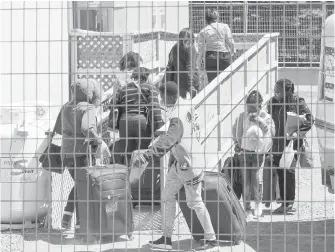  ?? THE CANADIAN PRESS ?? A group of asylum seekers arrives at temporary housing facilities last week at the border crossing at St. Bernard-de-Lacolle, Que.