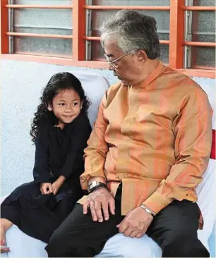  ?? ?? (Left pic) Sultan abdullah and Tunku azizah tossing the yee sang alongside LBS executive chairman Tan Sri Lim Hock San and his spouse at LBS Bina Group Bhd’s Chinese new year event. (Top pic) Sultan abdullah spending time with a young girl during His Majesty’s visit to Kampung orang asli Kuala Boh in Cameron Highlands, Pahang. — Bernama