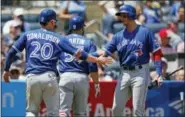  ?? KATHY WILLENS — THE ASSOCIATED PRESS ?? Toronto Blue Jays’ on-deck batter Troy Tulowitzki, right, greets the Josh Donaldson (20) and Russell Martin, center, after they scored on Kendrys Morales’ two-run single during the third inning of a baseball game against the New York Yankees in New...