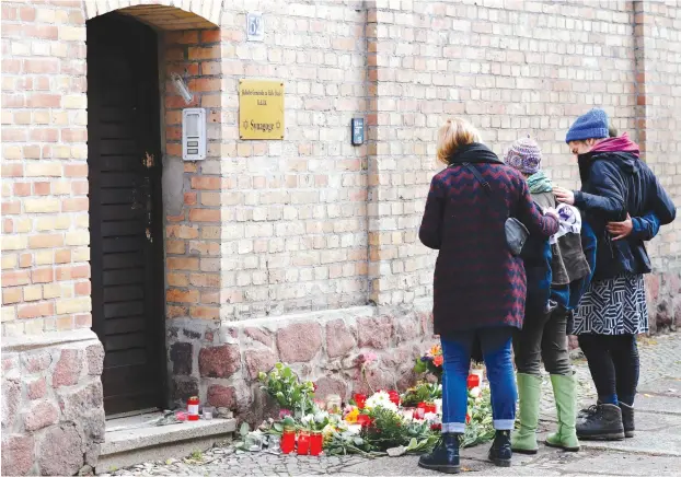  ?? (Fabrizio Bensch/Reuters) ?? MOURNERS GATHER outside the synagogue in Halle, Germany, yesterday, after two people were killed in a shooting on Yom Kippur, the day before.