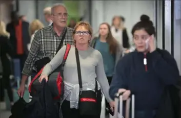  ?? Scott Olson/Getty Images ?? Travelers arrive Sunday in the internatio­nal terminal at O'Hare Internatio­nal Airport in Chicago.