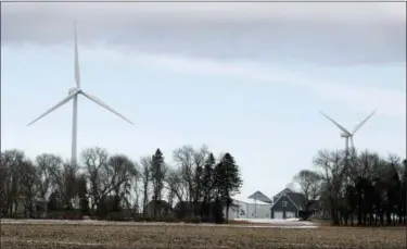 ?? CHARLIE NEIBERGALL — THE ASSOCIATED PRESS FILE ?? Wind turbines stand over a farmhouse near Northwood, Iowa. A new study out of Harvard finds that ramping up wind power in America would also dial up the nation’s temperatur­es.