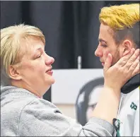  ?? THE CANADIAN PRESS/JONATHAN HAYWARD ?? Humboldt Broncos’ Nick Shumlanski, who was released from hospital earlier in the day, is comforted by a mourner during a vigil at the Elgar Petersen Arena, home of the Humboldt Broncos, to honour the victims of a fatal bus accident in Humboldt, Sask.,...