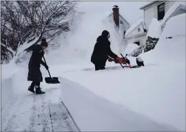  ?? CRAIG RUTTLE — THE ASSOCIATED PRESS ?? Susan Iannuzzi, left, and Linda Marzell of Binghamton, N.Y., clear a sidewalk after a heavy snowfall on a street in Binghamton, N.Y., on Thursday.