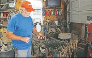  ??  ?? Lee Samuelson stirs up the coals on his blacksmith forge at his home in rural Holdrege, Neb.. (Kearney Hub/Ashley Bebensee)