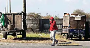  ?? ALFIAN RIZAL/JAWA POS ?? PINDAH PEMBUANGAN: Gerobak pengangkut sampah berada di depan TPS Pocan yang ditutupi seng kemarin.