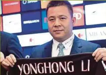  ??  ?? Chinese businessma­n and new owner of AC Milan Li Yonghong posing with a jersey of the club.