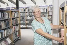  ??  ?? Library volunteer Lesley Bessant ready to welcome browsers back