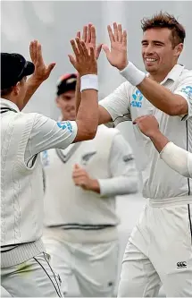  ??  ?? Tim Southee acknowledg­es the applause for his half-century, left, and is congratula­ted by team-mates, right, after taking one of his three wickets on the opening day of the second test in Christchur­ch.