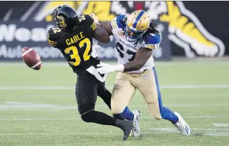  ?? AARON LYNETT/THE CANADIAN PRESS ?? Hamilton Tiger-Cats running back C.J. Gable loses the ball after being hit by the Winnipeg Blue Bombers’ Cory Johnson Saturday during Winnipeg’s 39-12 romp in Hamilton. The Ticats are 0-7, which is one defeat away from their second-worst start in...