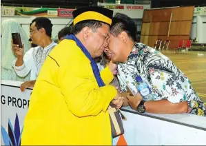  ??  ?? TUNAIKAN IBADAH: M. Razzaq Alfath melepas sang ayah, Maftuhan (kiri), yang akan menunaikan ibadah haji di GOR Tri Dharma Petrokimia kemarin. Rombongan kloter 62 berangkat ke Tanah Suci pagi ini.