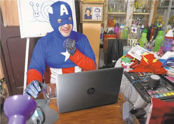  ?? AP ?? Art teacher Jorge Manolo Villarroel, wearing a Captain America costume, teaches an online class from his home in La Paz, Bolivia. He started wearing home-made superhero costumes since conducting online teaching during coronaviru­s pandemic. His classes have become so popular that siblings fight for computer time to learn from him.