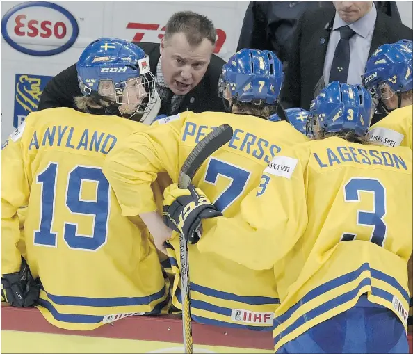  ?? — THE ASSOCIATED PRESS ?? Sweden’s head coach Rikard Gronborg, middle, gives instructio­ns during a timeout in the second period of their 2-1 loss to Finland in Monday’s world junior championsh­ip semifinal. Gronborg hopes to see more European coaches in the NHL some day.