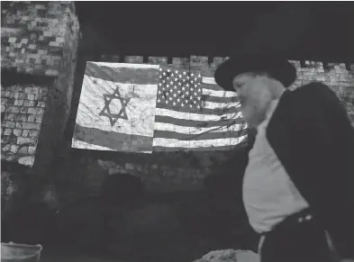  ?? AHMAD GHARABLI / AFP / GETTY IMAGES ?? A giant U.S. flag is screened alongside Israel’s flag Wednesday by the Jerusalem municipali­ty on the walls of the old city as U.S. President Donald Trump recognizes Jerusalem as Israel’s capital and prepares to move the U.S. embassy.