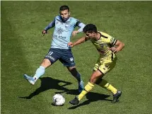 ??  ?? Phoenix defender Liberato Cacace gets a pass away under pressure from Sydney’s Kosta Barbarouse­s.