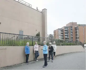  ??  ?? Residents of Treelane Estates at 103 Gorge Rd. East are living with the reality that the homeless campers have moved in next door into the Travelodge hotel. Above, Carol Judd, left, Dawn Adair, Jeannette Sloan, Judy Skidmore and Faye Cook stand beside the hotel, left, with their building and home in the background.