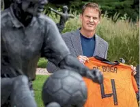  ??  ?? Appointmen­t… Netherland­s’ new coach De Boer holds his iconic No.4 shirt
