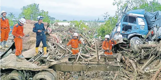  ?? AP ?? Members of a Myanmar rescue team work at a landslide-hit area in Paung township, Mon State, Myanmar, on Monday.