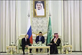  ?? (AP//Kremlin/Sputnik/Sergei Savostyano­v) ?? Saudi Crown Prince Mohammed bin Salman (right) and Russian President Vladimir Putin attend talks at the Al Yamamah Palace in Riyadh, Saudi Arabia, on Wednesday. At top is a picture showing Saudi King Salman.