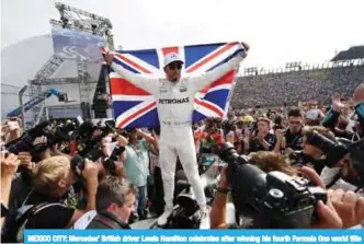  ??  ?? MEXICO CITY: Mercedes’ British driver Lewis Hamilton celebrates after winning his fourth Formula One world title despite finishing the Mexican Grand Prix in ninth place, at the Hermanos Rodriguez circuit in Mexico City. — AFP