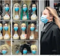  ?? IAN LANGSDON / EFE ?? Una mujer camina delante de una tienda de mascarilla­s ayer en París.