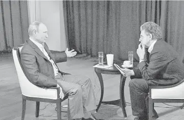  ??  ?? Russia’s President Putin (left) answers questions of ARD channel’s representa­tive Hubert Seipel during an interview for the channel in Vladivosto­k. Russia does not intend to demand early repayment of US$3 billion which it lent to Ukraine last year,...