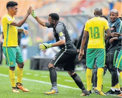  ?? Picture: GALLO IMAGES ?? ON TRACK: Itumeleng Khune, right, and Clayton Daniels celebrate Bafana Bafana’s victory