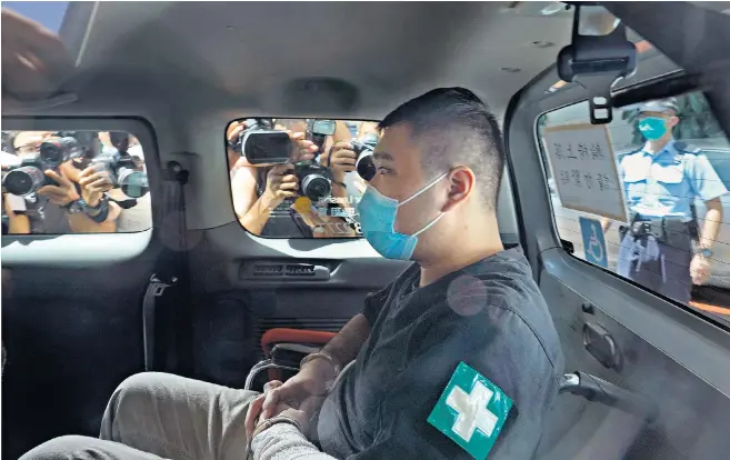  ??  ?? Tong Ying-kit arrives at court in a police van where he become the first person in Hong Kong to be charged under the new national security law introduced by Beijing